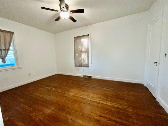 unfurnished room featuring a ceiling fan, visible vents, baseboards, and dark wood-style flooring