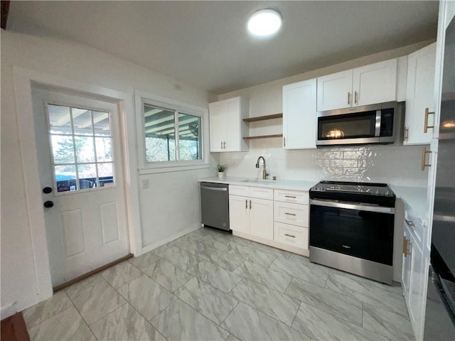 kitchen featuring marble finish floor, open shelves, appliances with stainless steel finishes, white cabinets, and a sink