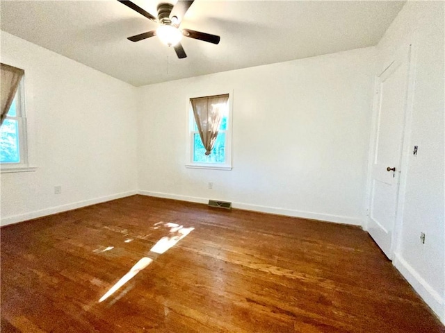 unfurnished room with baseboards, visible vents, a wealth of natural light, and wood finished floors