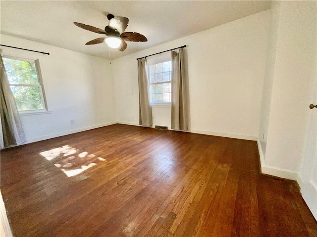 empty room featuring baseboards, visible vents, ceiling fan, and wood finished floors