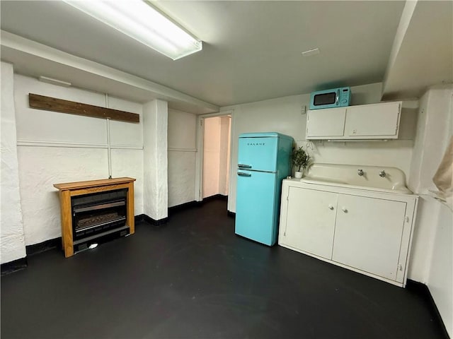 below grade area featuring freestanding refrigerator