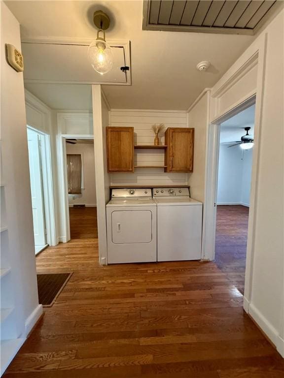 laundry room featuring dark wood-style floors, independent washer and dryer, cabinet space, and crown molding