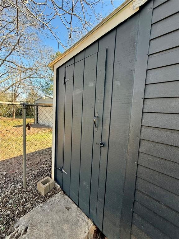 view of outbuilding featuring fence and an outbuilding