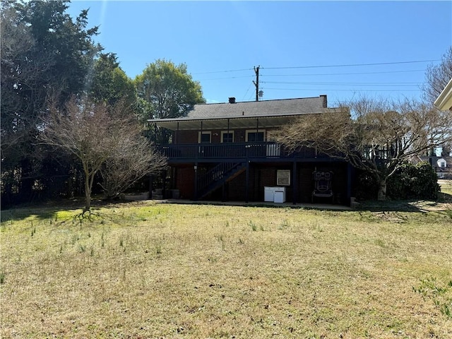 rear view of house with a wooden deck, stairs, and a yard