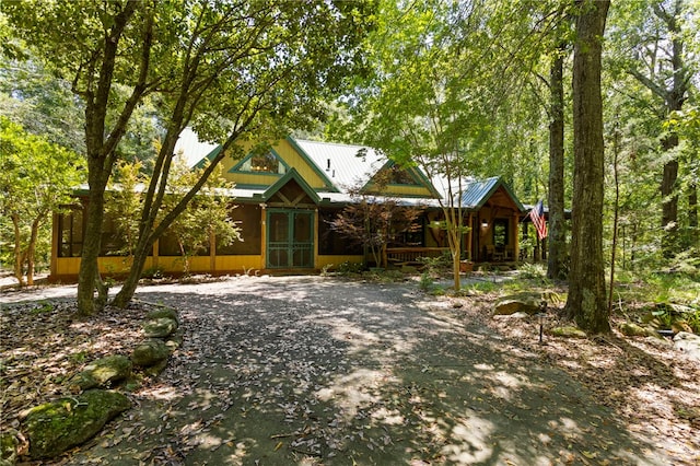 chalet / cabin featuring a porch and metal roof