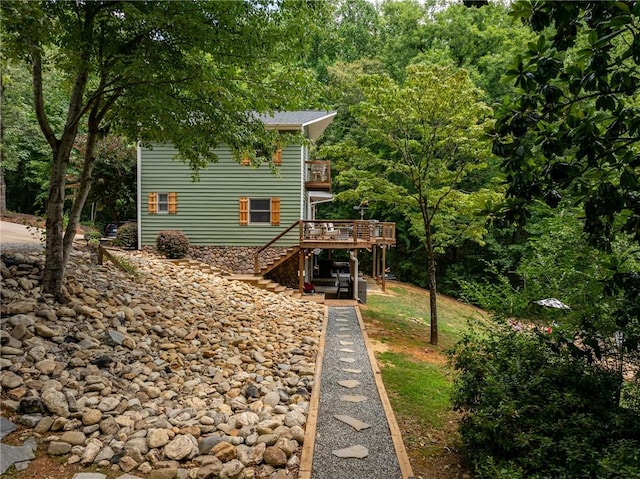 rear view of house with a wooden deck and stairs