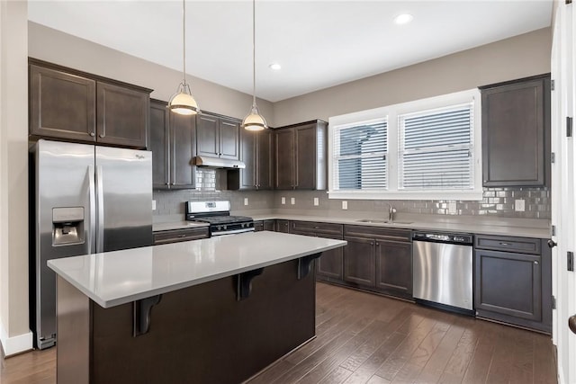 kitchen featuring dark wood-type flooring, a sink, dark brown cabinets, appliances with stainless steel finishes, and backsplash