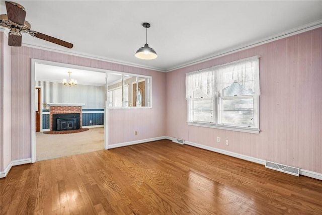 interior space featuring a wealth of natural light, visible vents, crown molding, and wood finished floors