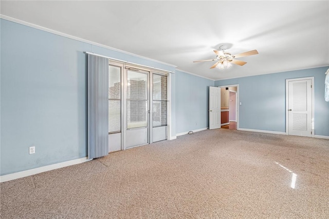 spare room featuring ornamental molding, carpet flooring, ceiling fan, and baseboards