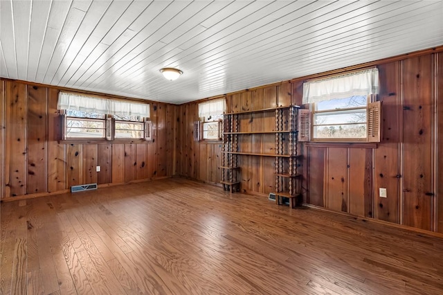 spare room featuring a wealth of natural light, wooden ceiling, visible vents, and wood finished floors