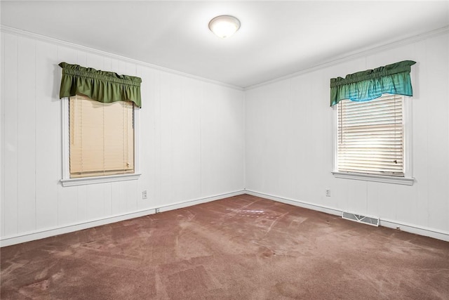 spare room featuring carpet floors, visible vents, and crown molding