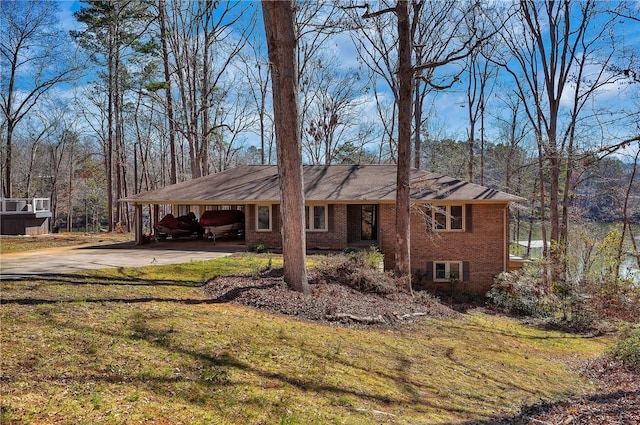 ranch-style house featuring an attached carport, concrete driveway, brick siding, and a front lawn