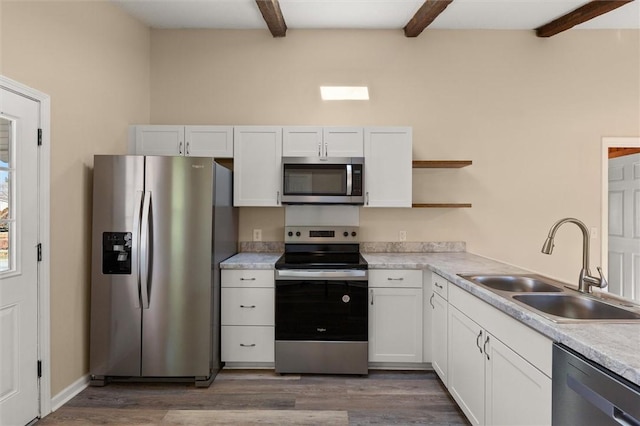 kitchen with white cabinets, appliances with stainless steel finishes, open shelves, and a sink