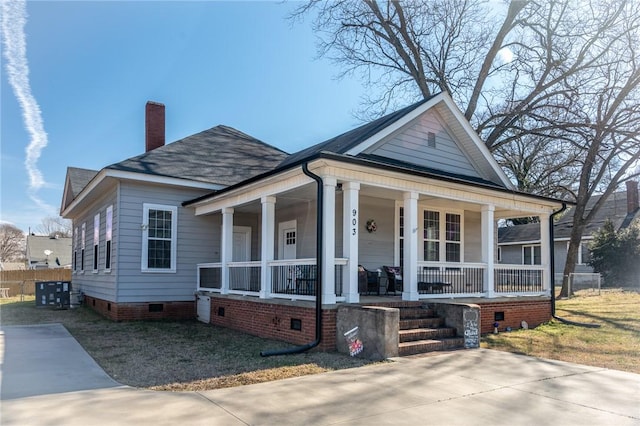 view of front facade featuring crawl space, a chimney, a front lawn, and a porch