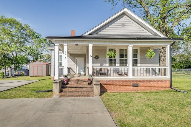 view of front of home with a storage shed, a front yard, covered porch, and an outdoor structure
