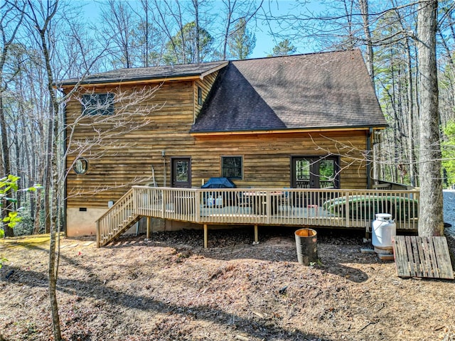 view of front of home with a deck, crawl space, and roof with shingles