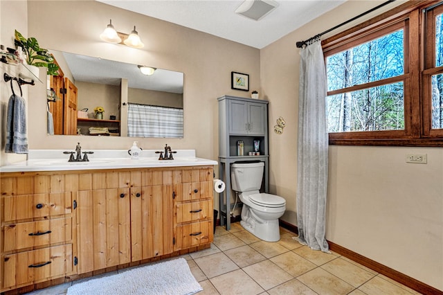 full bathroom featuring baseboards, a sink, toilet, and tile patterned floors