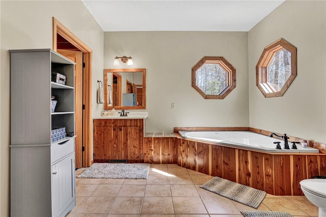 full bath featuring toilet, a garden tub, tile patterned flooring, and vanity