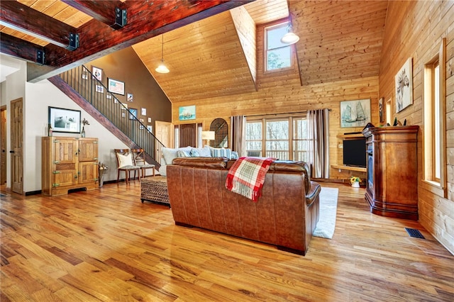 living area with light wood finished floors, visible vents, stairway, wooden ceiling, and beamed ceiling