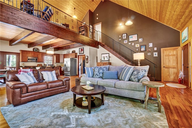 living area featuring wooden ceiling, stairs, light wood finished floors, and beamed ceiling