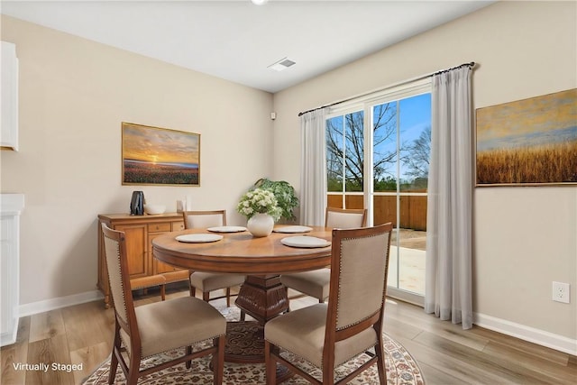 dining area featuring light wood-type flooring, baseboards, and visible vents