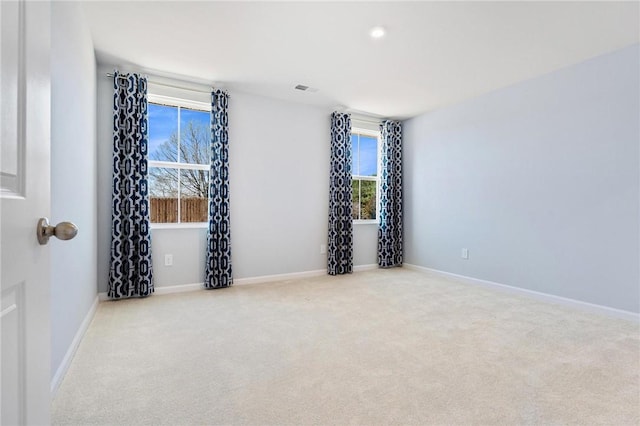 carpeted empty room featuring visible vents and baseboards