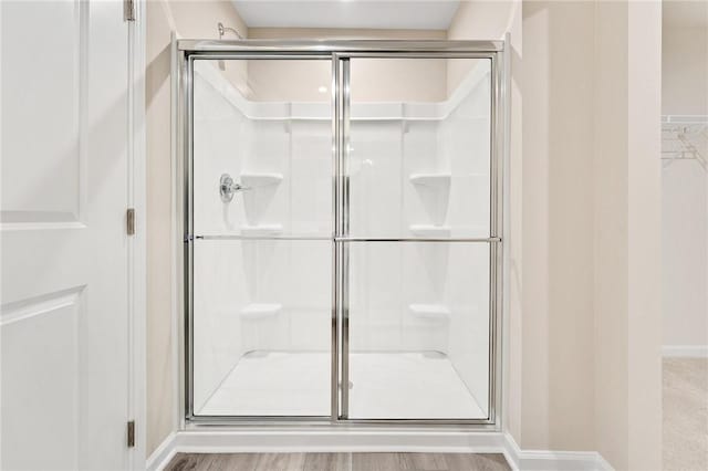 full bathroom featuring a stall shower and baseboards