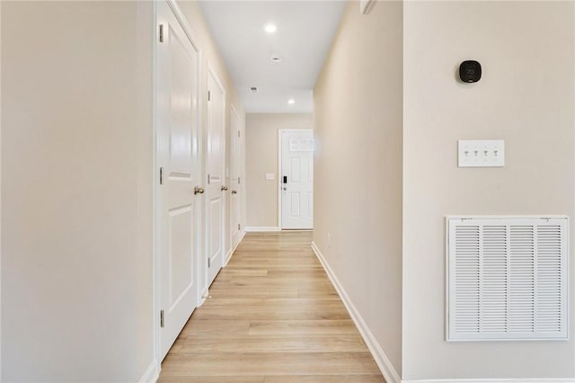 hall featuring light wood-type flooring, visible vents, baseboards, and recessed lighting