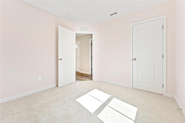 unfurnished bedroom with carpet floors, baseboards, and visible vents