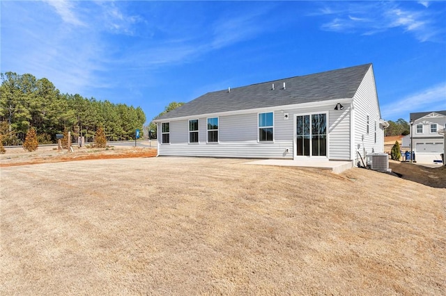 back of house with central AC, a yard, and a patio