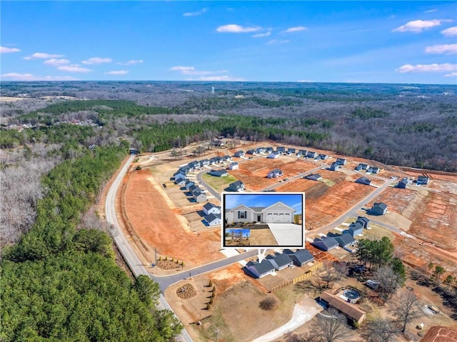 birds eye view of property featuring a forest view