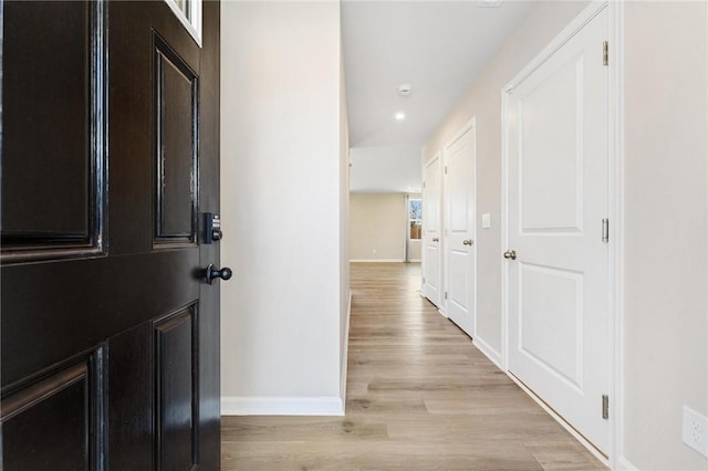 hall with light wood-type flooring and baseboards