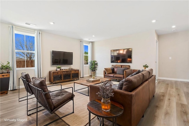 living room with baseboards, recessed lighting, visible vents, and light wood-style floors