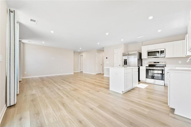 kitchen with visible vents, light wood-style flooring, appliances with stainless steel finishes, open floor plan, and a kitchen island