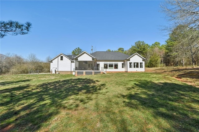 rear view of property with a yard and a sunroom