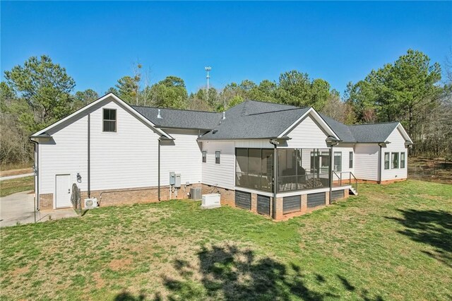 rear view of house with a sunroom, cooling unit, and a lawn