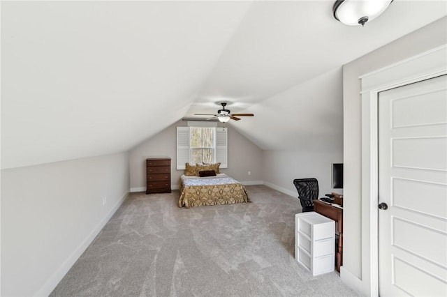 carpeted bedroom with a ceiling fan, vaulted ceiling, and baseboards