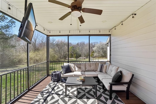 sunroom / solarium with rail lighting and a ceiling fan