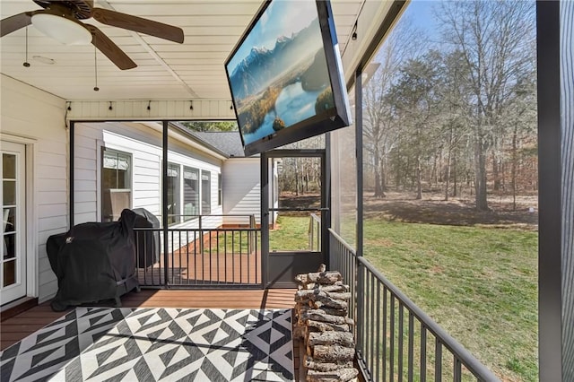 wooden deck featuring a ceiling fan, a yard, and grilling area