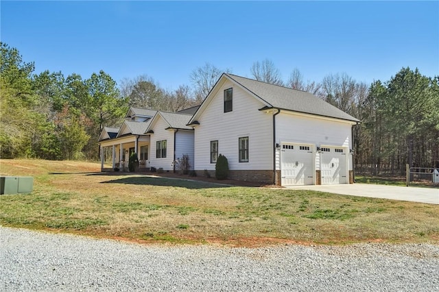 view of front facade with a front yard, covered porch, driveway, and an attached garage