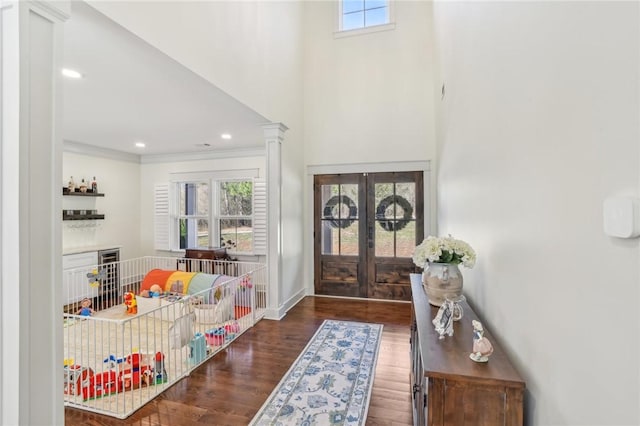 entryway featuring ornamental molding, french doors, plenty of natural light, and wood finished floors