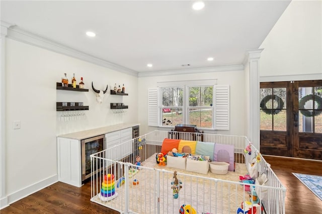 rec room featuring french doors, dark wood-type flooring, wine cooler, and crown molding