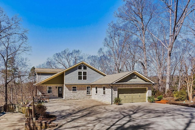 view of front of home featuring stone siding, an attached garage, and concrete driveway