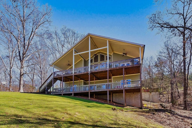 back of property featuring ceiling fan and a lawn