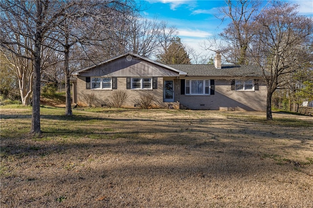 view of front of property with a chimney, brick siding, crawl space, and a front yard