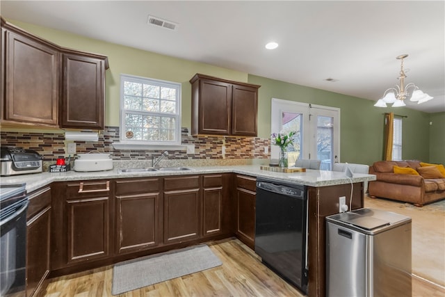 kitchen featuring black dishwasher, decorative backsplash, a sink, dark brown cabinets, and a peninsula