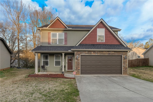 view of front of home with a front yard, driveway, an attached garage, and fence