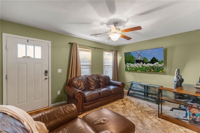 living room featuring a ceiling fan, visible vents, and baseboards