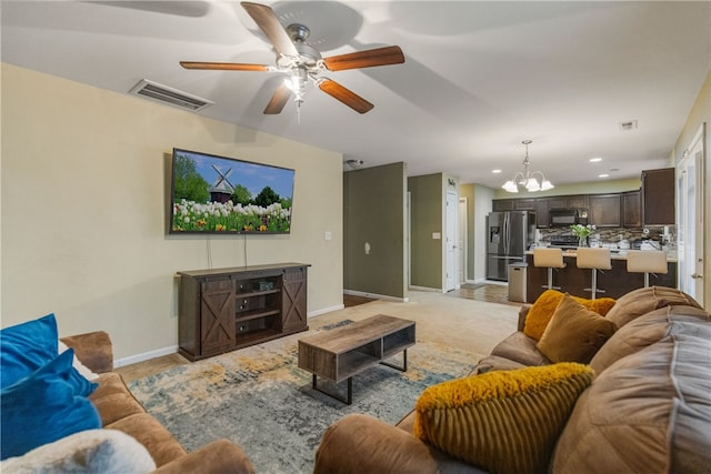 living area featuring recessed lighting, visible vents, baseboards, and ceiling fan with notable chandelier