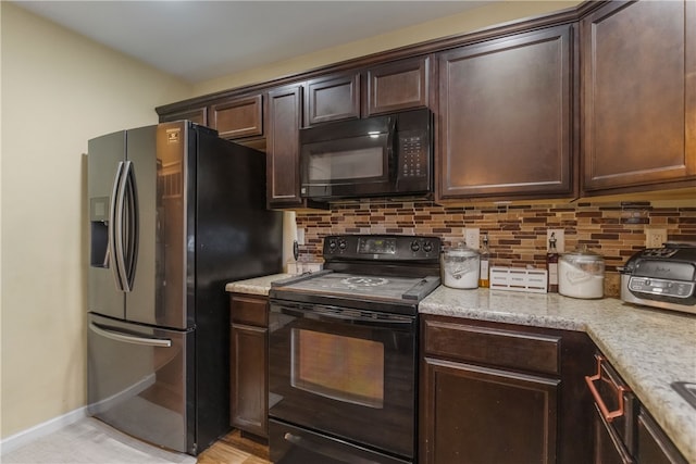 kitchen with light stone counters, dark brown cabinetry, baseboards, backsplash, and black appliances